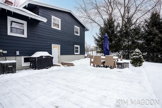 snow covered property with central AC unit