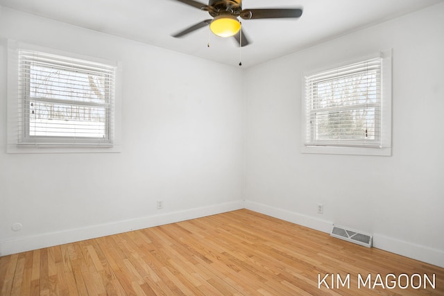 spare room featuring visible vents, baseboards, and wood finished floors