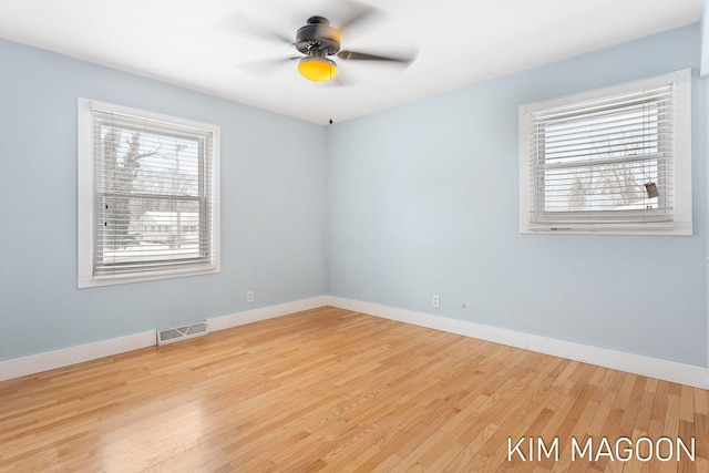 empty room featuring ceiling fan, light wood-type flooring, visible vents, and baseboards