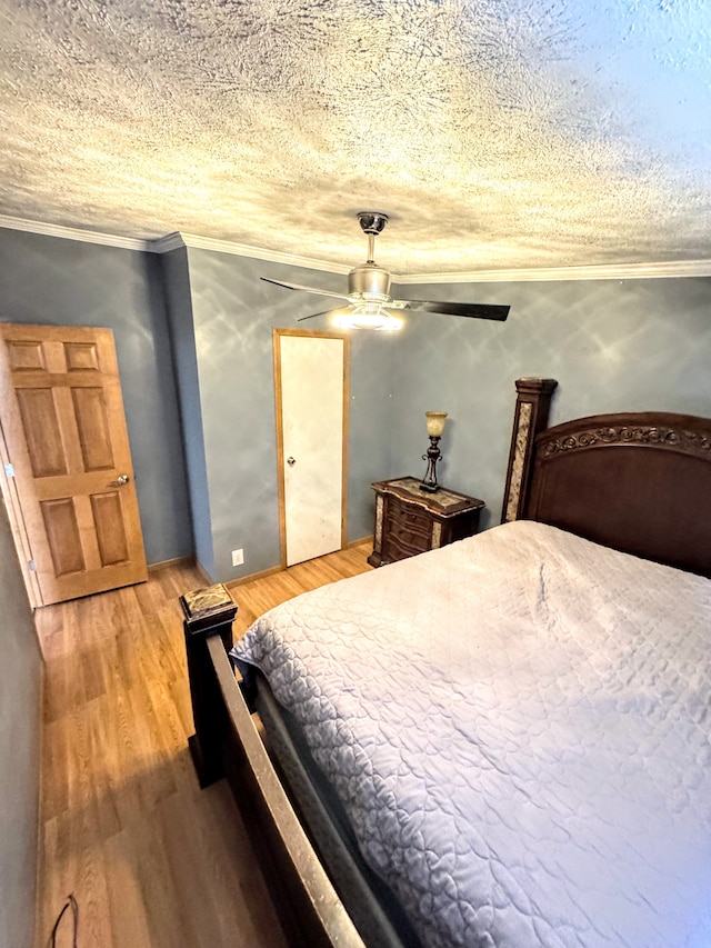 bedroom with a textured ceiling, light wood-style floors, a ceiling fan, and crown molding