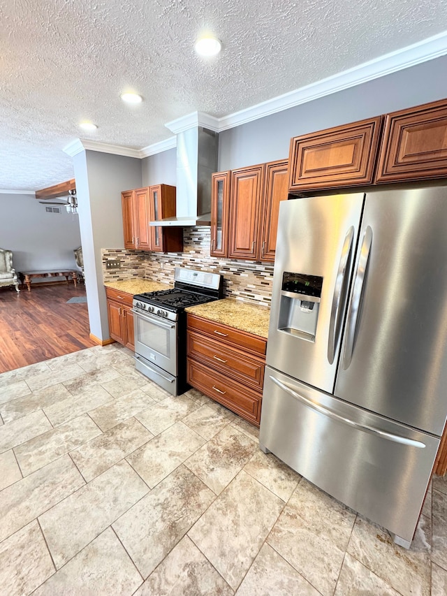 kitchen featuring wall chimney exhaust hood, appliances with stainless steel finishes, brown cabinets, ornamental molding, and light stone countertops