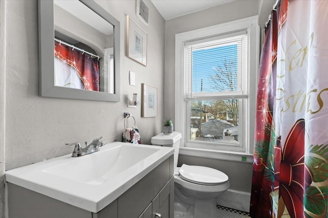 bathroom featuring visible vents, vanity, and toilet