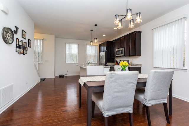 dining area with dark wood-style flooring, visible vents, and baseboards