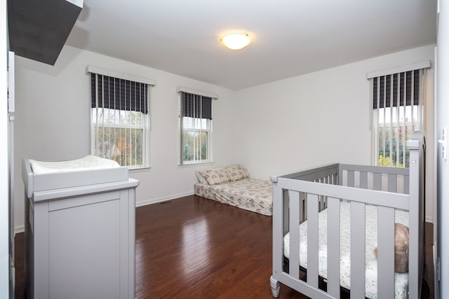 bedroom featuring dark wood-style floors and baseboards