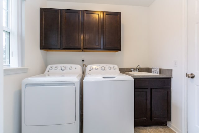 laundry area with cabinet space, washer and clothes dryer, and a sink