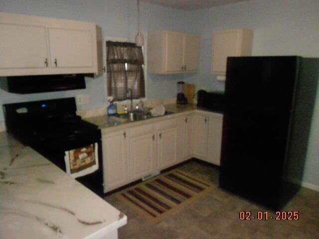 kitchen with light countertops, black appliances, a sink, and range hood