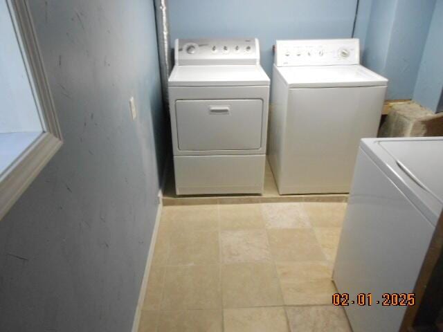 laundry room featuring laundry area, baseboards, washing machine and clothes dryer, and light tile patterned floors