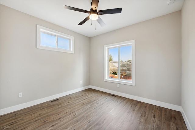 unfurnished room featuring visible vents, ceiling fan, baseboards, and wood finished floors