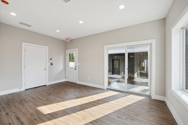 interior space with baseboards, wood finished floors, visible vents, and recessed lighting