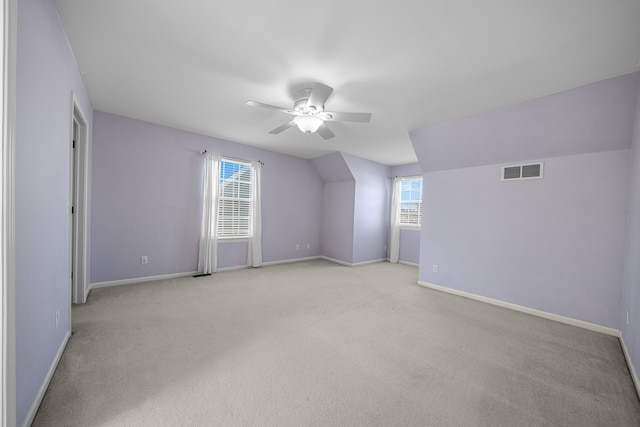 bonus room with visible vents, baseboards, light colored carpet, lofted ceiling, and a ceiling fan