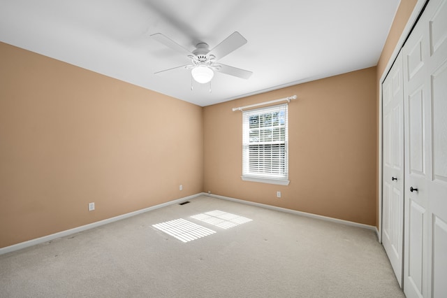 unfurnished bedroom with a closet, light carpet, baseboards, and visible vents