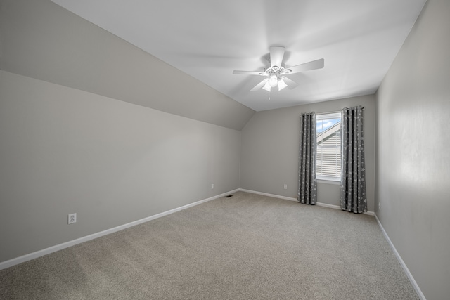 additional living space featuring light carpet, a ceiling fan, lofted ceiling, and baseboards