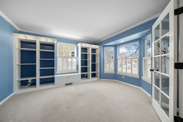 carpeted empty room with visible vents, crown molding, and baseboards