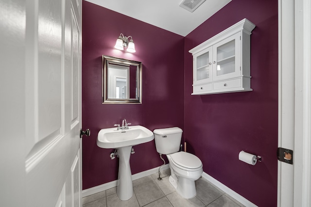 bathroom with tile patterned floors, toilet, baseboards, and visible vents