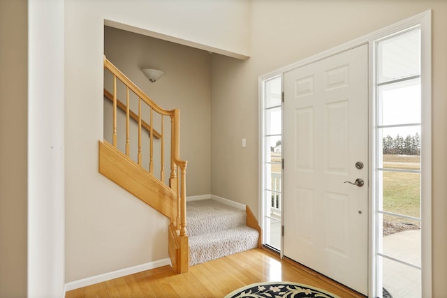 foyer featuring stairway, baseboards, and wood finished floors