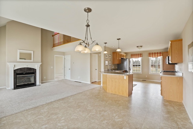 kitchen featuring light carpet, a fireplace, open floor plan, and stainless steel fridge with ice dispenser