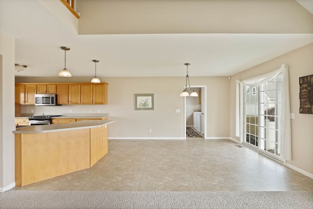 kitchen with decorative light fixtures, stainless steel appliances, light countertops, a towering ceiling, and baseboards