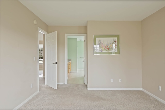 unfurnished bedroom with light carpet and baseboards