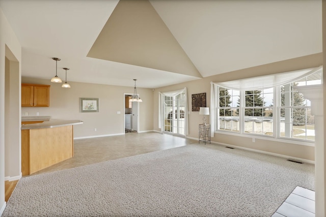 unfurnished living room with light carpet, high vaulted ceiling, visible vents, and baseboards