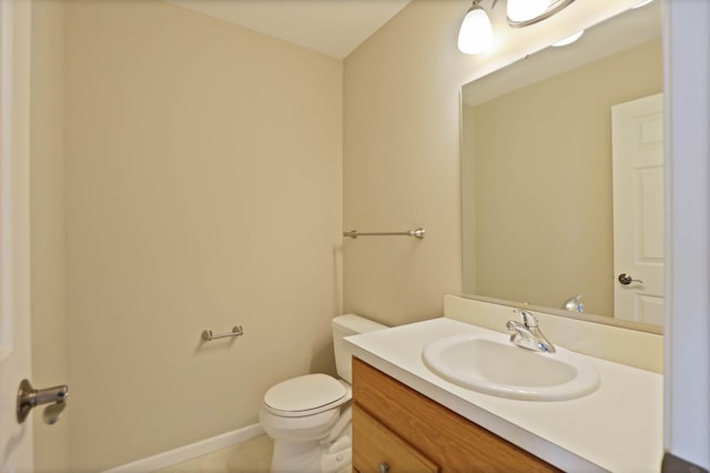 bathroom with toilet, baseboards, and vanity