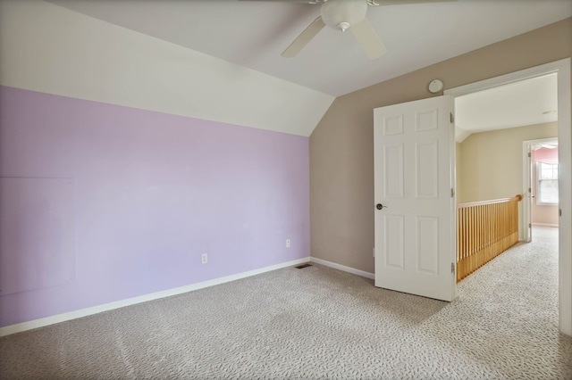 additional living space featuring baseboards, visible vents, a ceiling fan, vaulted ceiling, and carpet flooring