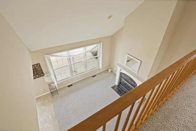 corridor featuring vaulted ceiling, carpet, visible vents, and baseboards