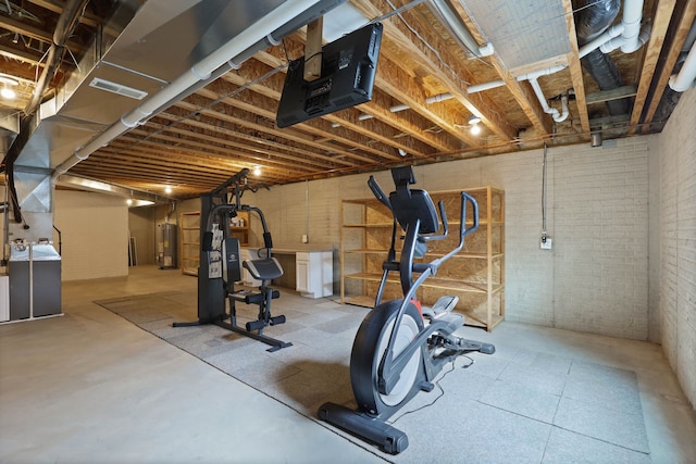 workout room featuring gas water heater, visible vents, and brick wall