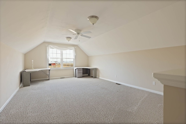 additional living space featuring lofted ceiling, visible vents, carpet flooring, ceiling fan, and baseboards