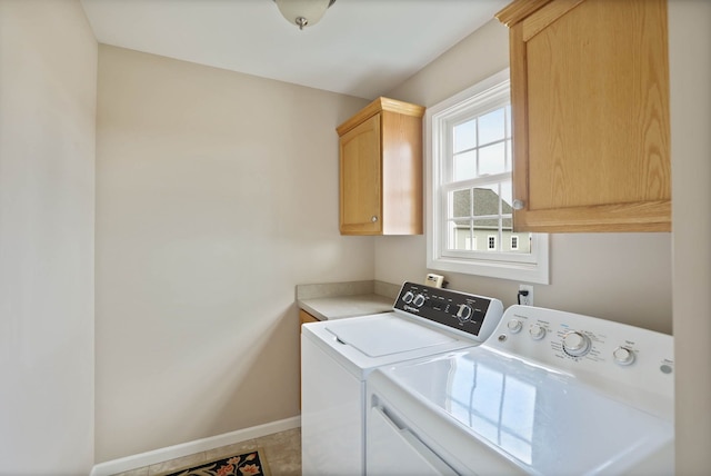 laundry area featuring cabinet space, baseboards, and washing machine and clothes dryer