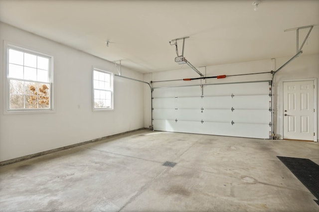 garage featuring a garage door opener and baseboards