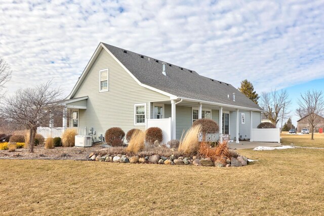 back of house with a yard, roof with shingles, and a patio area