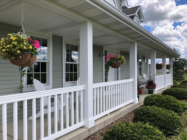 view of property exterior featuring a porch and roof with shingles