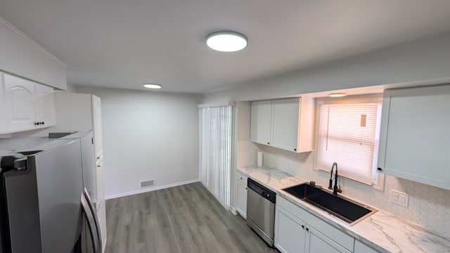 kitchen featuring a sink, visible vents, white cabinets, dishwasher, and tasteful backsplash