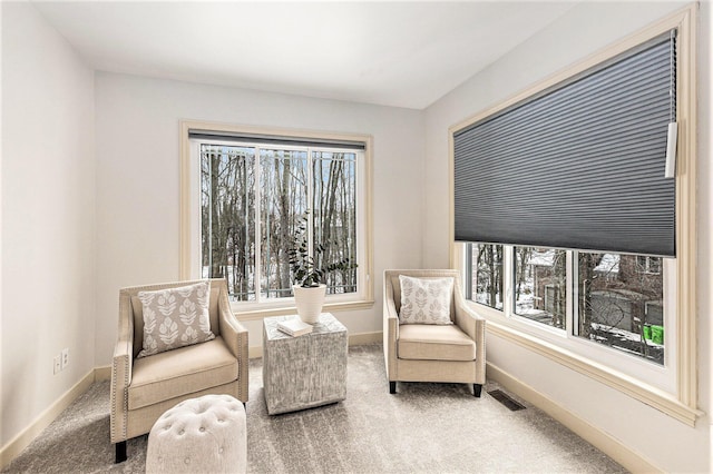 sitting room with carpet floors, visible vents, and baseboards