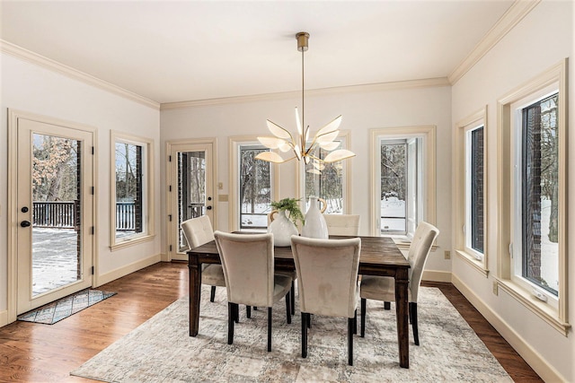 dining room featuring a healthy amount of sunlight, dark wood-style floors, and baseboards