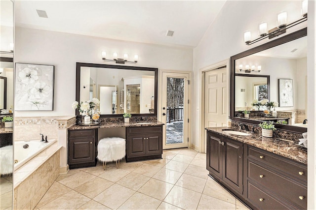 bathroom featuring tile patterned floors, a garden tub, vaulted ceiling, and vanity