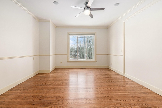 unfurnished room featuring baseboards, wood finished floors, and ornamental molding