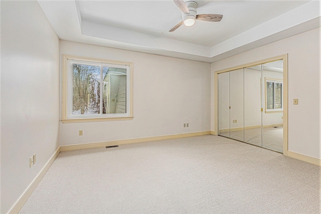 unfurnished bedroom featuring visible vents, baseboards, ceiling fan, carpet floors, and a closet