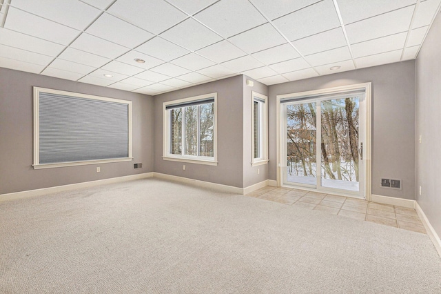 unfurnished room featuring light carpet, visible vents, baseboards, and a drop ceiling