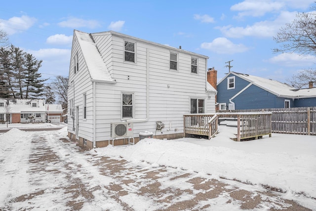 snow covered property featuring ac unit, fence, and a deck