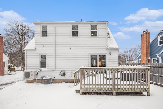 snow covered property with central AC unit, ac unit, fence, and a wooden deck