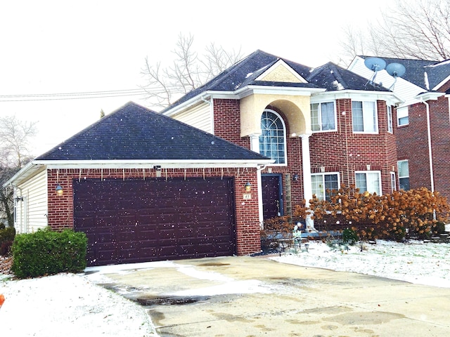 traditional home featuring a garage, driveway, and brick siding