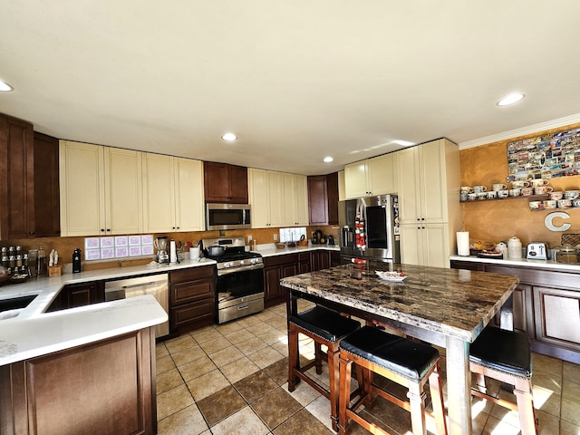 kitchen with appliances with stainless steel finishes, recessed lighting, cream cabinetry, and light countertops