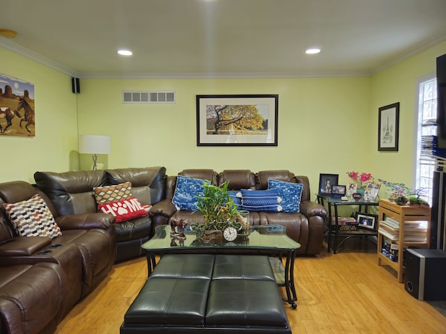 living room with ornamental molding, recessed lighting, visible vents, and light wood-style floors