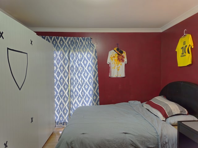 bedroom featuring ornamental molding and light wood-style floors