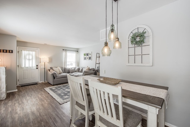 dining space with baseboards and dark wood finished floors