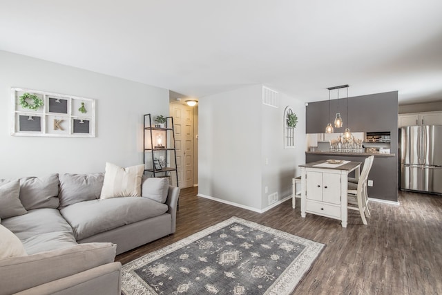 living area with baseboards, visible vents, and dark wood-type flooring