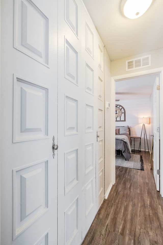 hallway with dark wood-style flooring and visible vents