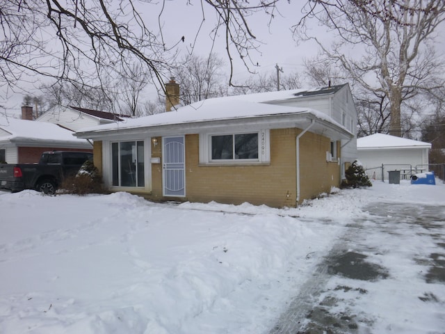 view of front of home featuring brick siding and a chimney