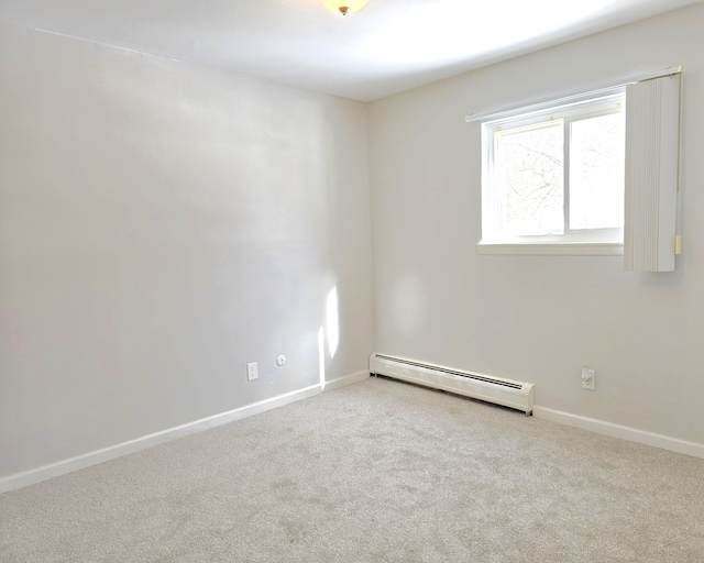 empty room featuring baseboards, a baseboard heating unit, and light colored carpet